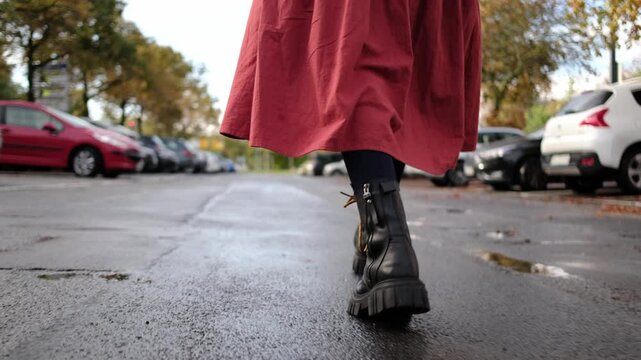 Female Legs In Black Leather Boots Stride Confidently Down City Streets, Girl Walking after rain