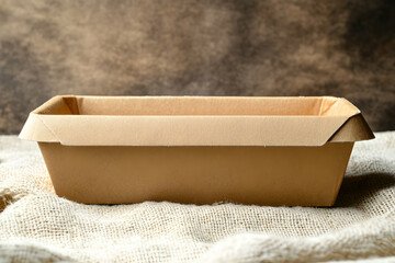 Empty Cardboard Baking Loaf Pan on Burlap Fabric