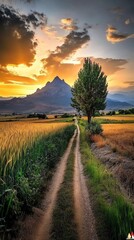 Obraz premium A serene landscape featuring a dirt path leading through fields, with a majestic mountain backdrop under a vibrant sunset sky.