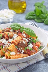 Rigatoni alla Norma pasta with eggplant and tomato, served with basil and ricotta salata, vertical