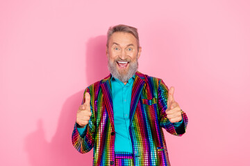 Charismatic elderly man in a colorful suit posing against a vibrant pink background