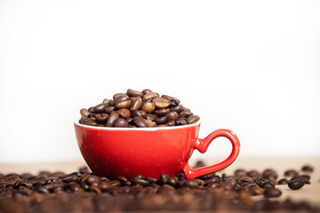 red cup with coffee beans on a light background.