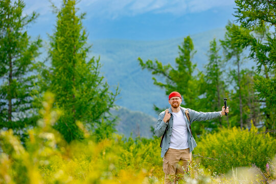 Happy traveler man taking selfie and recording video in beautiful mountains, concept travel vlog.