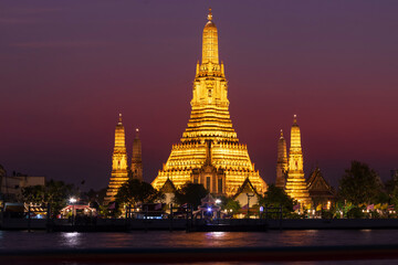 Naklejka premium Wat Arun Ratchawararam Ratchawaramahawihan or Wat Arun (Temple of Dawn) is a Buddhist temple along the Chao Phraya river at twilight in Bangkok, Thailand.