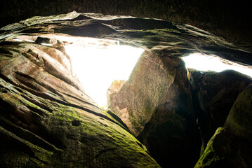 Unique rock formations light up a hidden cave in a remote location during midday