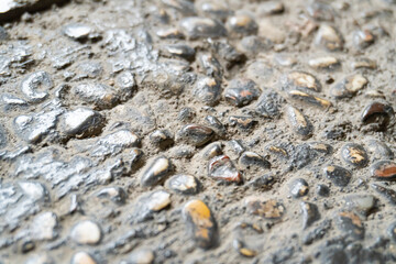 Close-up of a cobblestone or pebblestone concrete road surface. A natural stone-textured background concept.