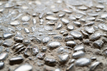 Close-up of a cobblestone or pebblestone concrete road surface. A natural stone-textured background concept.