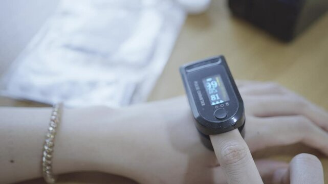 A close-up image of a smart health monitor on a person's wrist, displaying vital signs such as heart rate and oxygen levels. The device highlights the integration of technology in personal health moni