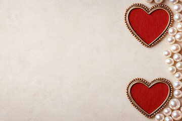 Red hearts and pearls on beige background, romantic design