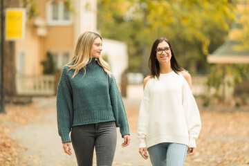 Two beautiful young women walking and laughing