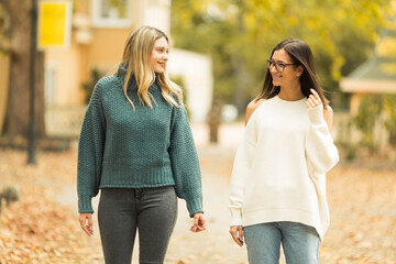 Two beautiful young women walking and talking