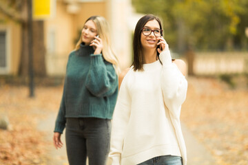 Two beautilful young women talking on the phone