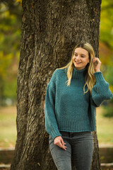 Portrait of beautiful blonde young woman in green sweater