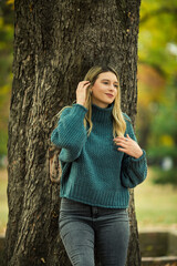 Portrait of beautiful blonde young woman in green sweater