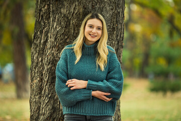 Portrait of beautiful blonde young woman in green sweater