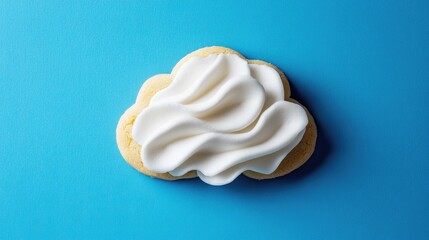 A delightful cookie shaped like a cloud, with soft white frosting and delicate edges, set against a bright blue background