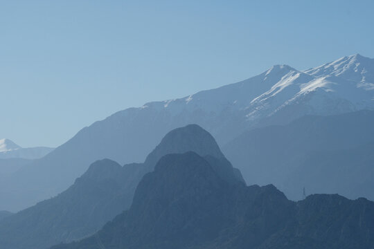 Snowy mountains on a sunny day. Mountain peak against blue sky. Antalya, Türkiye