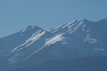 Snowy mountains on a sunny day. Mountain peak against blue sky. Antalya, Türkiye