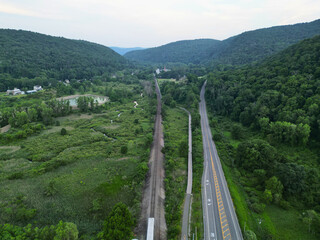 aerial view of harlem valley rail trail next to train tracks and a road near the wassaic train...