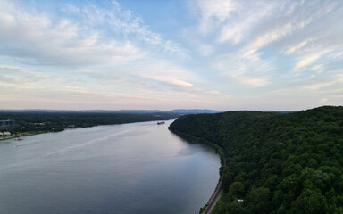 container ship in the distance sailing along hudson river at sunset (scenic outdoor scene highland poughkeepsie upstate new york) water transport shipping