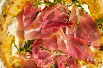 Delicious Prosciutto Pizza with Arugula and Creamy Cheese Topping