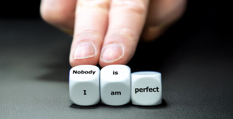 Hand turns dice and changes the expression 'I am perfect' to 'nobody is perfect'.