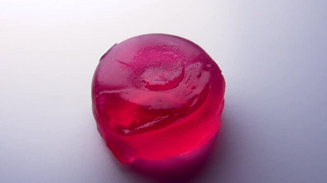 Red lollipop candy on white surface