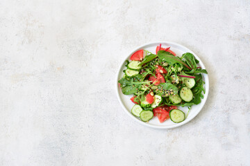 Fresh Green Salad with cucumber, tomato, greenery and seeds copy space
