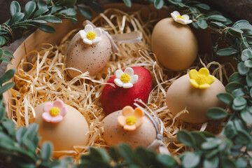 A decorative nest for Easter displays colorful eggs with floral accents, nestled in soft straw and...
