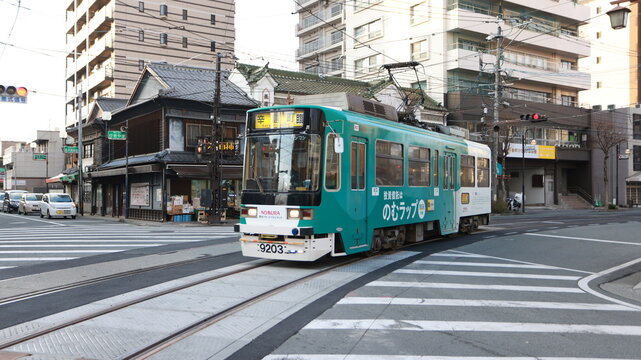 Kumamoto, Japan -January 15 2025:the tram pass through the old coffee shop which named Nagasaki Jiro Kissa Shitsu. it is one of heritage and traditional cafe in Kumamoto.
