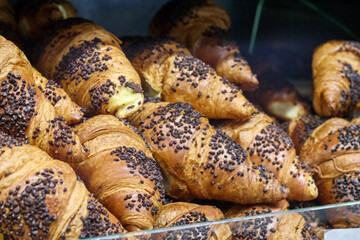
Several fresh, delicious looking cupcakes sprinkled with chocolate chips and placed in a glass display case.