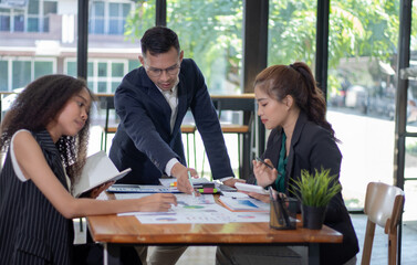 Group of Asian businessmen and women collaborating during team meeting in modern office High quality real estate business technology