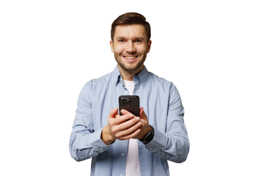 Man smiling while holding a smartphone and looking directly at the camera in a bright setting