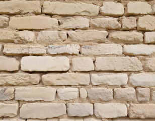 Fototapeta premium Rustic outdoor scene aged brick wall pale beige and cream tones textured environment close-up view sunbleached rustic charm for home design