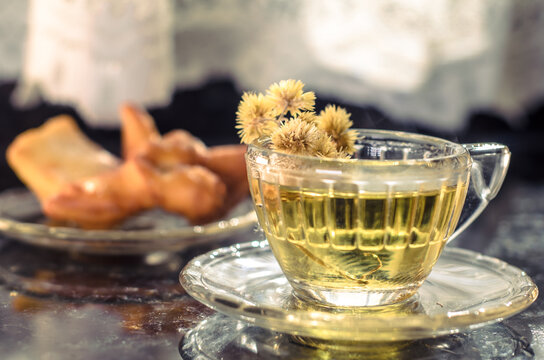 x&iacute;cara de ch&aacute; de camomila com doce de confeitaria
