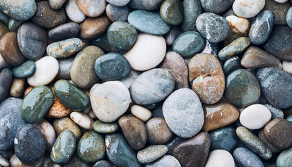 Smooth wet pebbles, texture background. Sea or ocean shore beach. Top view.