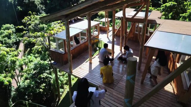 Design an eco-friendly educational facility in the heart of a rainforest, ensuring minimal environmental impact and maximal connection to nature