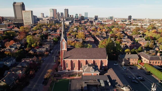 Red brick classic and vintage church with steeple in historic district German Village outside Columbus, Ohio for Christian and Catholic religious gatherings, sermons, and ceremony along High Street