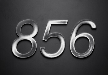 Chrome metal 3D number design of 856 on grey background.