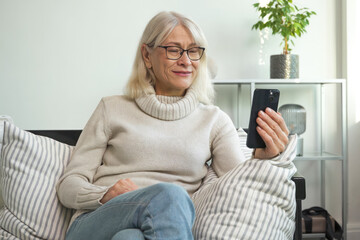 Senior woman smiling while talking on her smartphone
