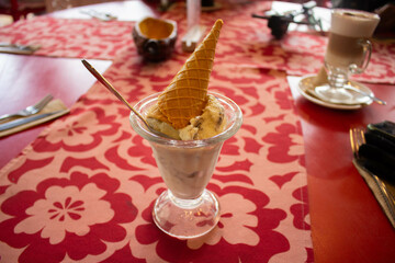 helado de vasinilla servido en copa y con cono en el tope