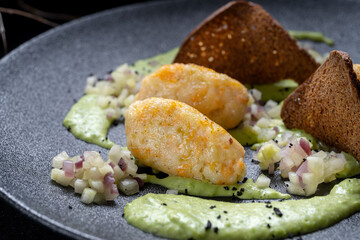 Savor gourmet potato gnocchi with creamy avocado sauce and crispy chips for texture