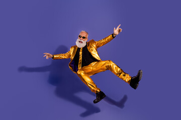 Obraz premium Full length photo of fashionable old showman falling have fun wear glamour golden garment isolated on violet color background