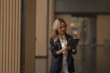 Businesswoman working on a tablet in a contemporary workspace. Capturing ambition, efficiency, and...