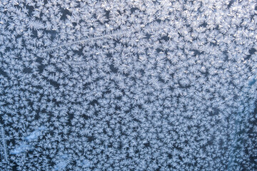Frosty pattern on glass. Winter crystals on glass. Abstract background, selective focus.