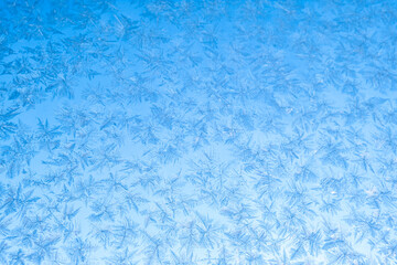 Frosty pattern on glass. Winter crystals on glass. Abstract background, selective focus.