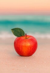 Vibrant Red Apple on Wet Sand with Ocean and Sunset Reflections in Background