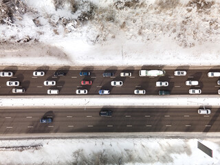  View from the height of the highway clogged with cars. A big long traffic jam of cars moving to...
