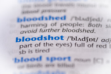 Bloodshot word in a dictionary. Selective focus, close up.