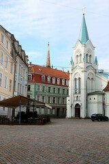 Photo with a view of a church and historic buildings on one of the squares in the historic center of Riga, Latvia